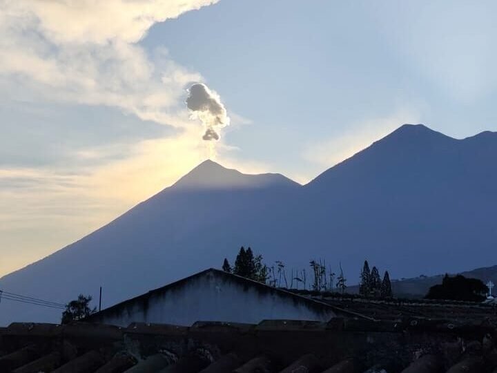 Antigua Guatemala from a rooftop with colonial rooftops and Volcán de Fuego y Acatenango in the background